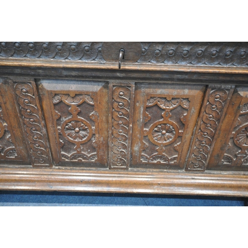 1310 - A GEORGIAN AND LATER OAK COFFER, with a hinged lid, twin mask carving, geometric and foliate panels,... 