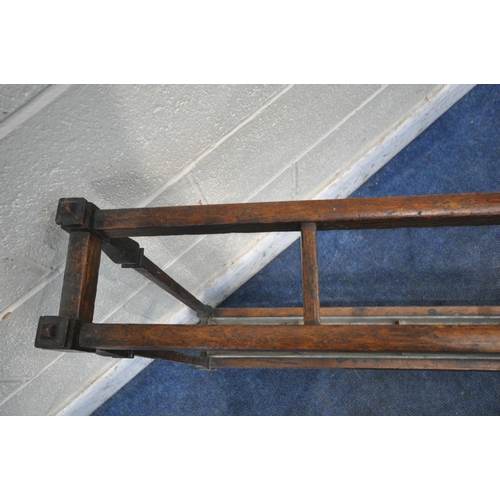 1314 - A 20TH CENTURY OAK UMBRELLA/STICK STAND, with five divisions, on square supports, with a long metal ... 