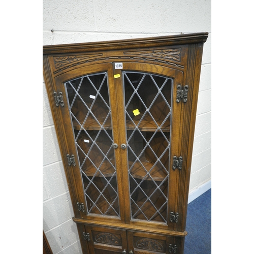 1375 - AN OLD CHARM OAK CORNER CUPBOARD, the double glazed doors enclosing two fixed shelves, above two cup... 