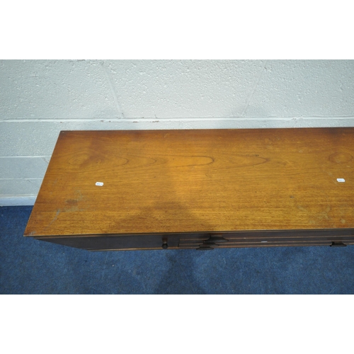 1393 - A MID CENTURY TEAK SIDEBOARD, fitted with two cupboard doors, flanking three drawers, on square tape... 