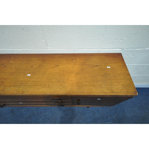 1393 - A MID CENTURY TEAK SIDEBOARD, fitted with two cupboard doors, flanking three drawers, on square tape... 