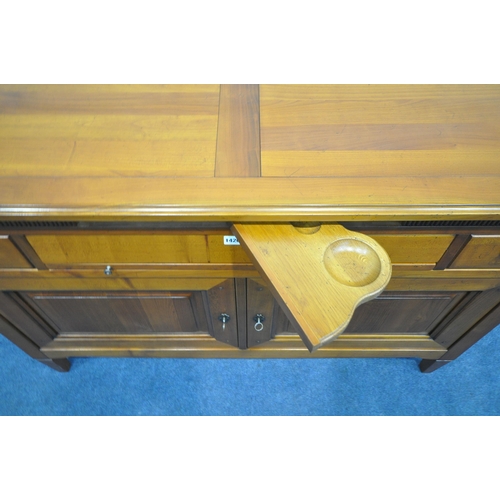 1420 - A REPRODUCTION CHERRYWOOD SIDEBOARD, fitted with a revolving pen tidy, two drawers flanking a centra... 