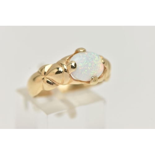 107 - A YELLOW METAL SYNTHETIC OPAL RING, oval synthetic opal cabochon, in a four claw setting, textured s... 