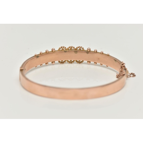 119 - A 9CT GOLD EDWARDIAN BANGLE, rose gold hinged bangle, set with three green stones assessed as two sm... 