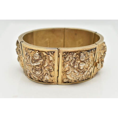 143 - A VICTORIAN GILT BRACELET, comprised of six slightly tapered panels, embossed with an Indian design,... 