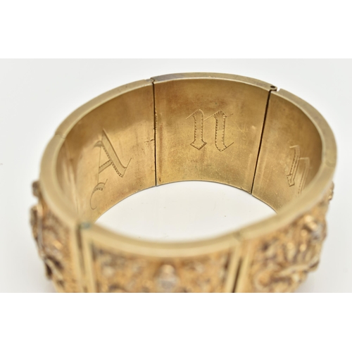 143 - A VICTORIAN GILT BRACELET, comprised of six slightly tapered panels, embossed with an Indian design,... 