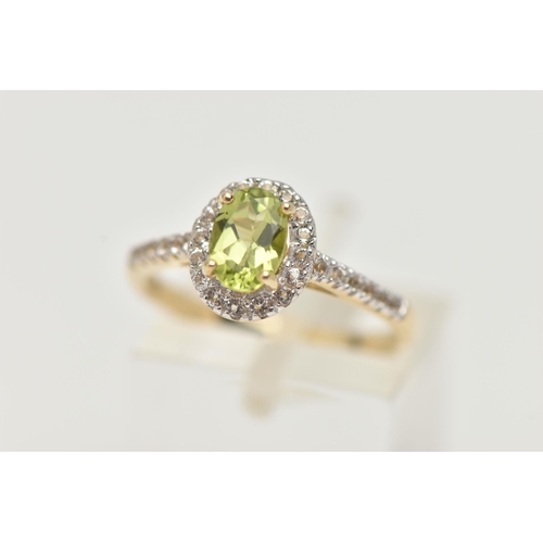 33 - A 9CT GOLD PERIDOT AND DIAMOND RING, an oval cut peridot, set with a surround of round brilliant cut... 