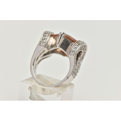 36 - A WHITE METAL DRESS RING, principally set with a large square cut orange cubic zirconia, leading on ... 