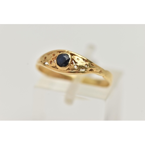 67 - A YELLOW METAL SAPPHIRE RING, set with a single circular cut dark blue sapphire, open work surround,... 