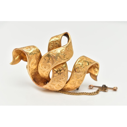 79 - A LATE 19TH CENTURY YELLOW METAL BROOCH, of interwoven ribbon design with scroll embossed detail, br... 