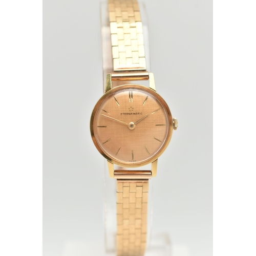 80 - A 9CT GOLD ETERNA MATIC WRISTWATCH, the textured champagne coloured dial, with gold coloured hourly ... 