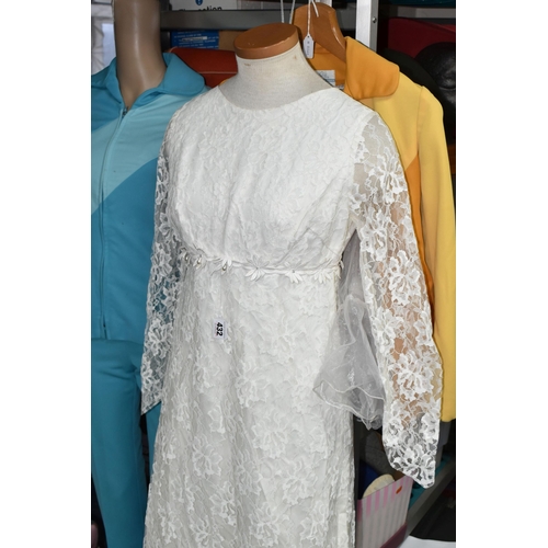 432 - A SHOP MANNEKIN AND THREE 1970S LADIES' OUTFITS, comprising a cream long sleeved lace wedding dress ... 