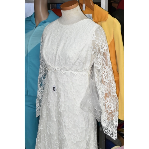 432 - A SHOP MANNEKIN AND THREE 1970S LADIES' OUTFITS, comprising a cream long sleeved lace wedding dress ... 