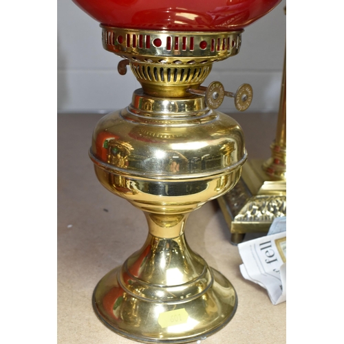 601 - THREE BRASS OIL LAMPS, with shades and chimneys, the tallest with column style base approximately 67... 