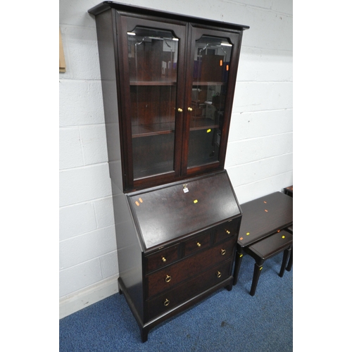 1204 - A STAG MINSTREL BUREAU BOOKCASE, the top with two glazed doors, enclosing two adjustable shelves, th... 