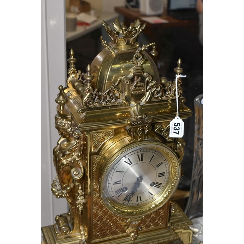 537 - A LATE 19TH CENTURY FRENCH BRASS MANTEL CLOCK, with a dome top with a coronet finial, surrounded by ... 