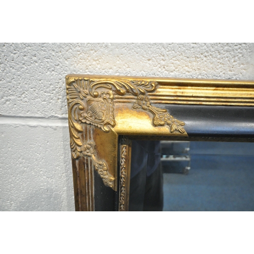 1201 - A RECTANGULAR GILT AND EBONISED FRAME BEVELLED EDGE WALL MIRROR, each corner with foliate detail, 13... 