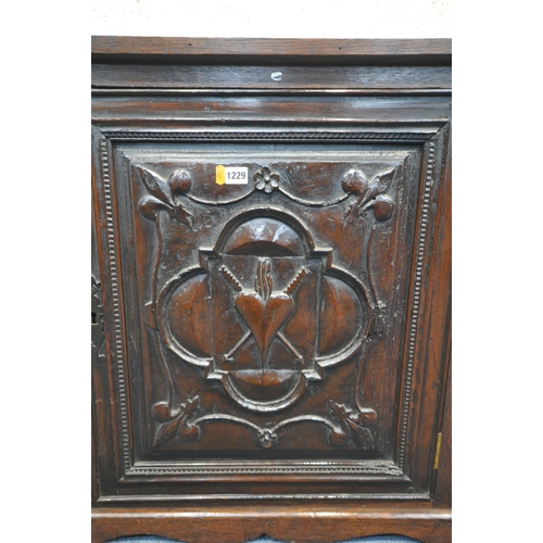 1229 - A GEORGIAN OAK HANGING CORNER CUPBOARD, with a later mahogany door panel depicting fleur de lis, qua... 