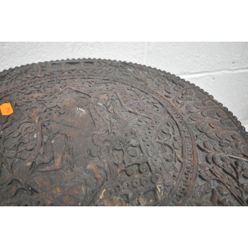 1233 - A 19TH CENTURY ORIENTAL PADAUK TWO TIER OCCASIONAL TABLE, the top circular surface carving depicting... 