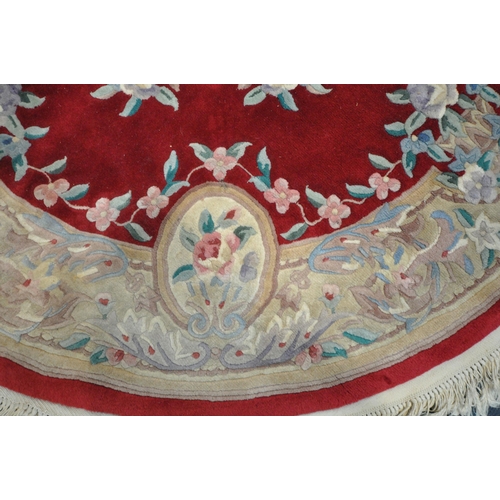 1262 - A RED AND CREAM CIRCULAR CHINESE WOOLLEN RUG, with central medallion and foliate details, diameter 1... 