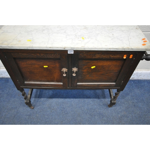 1277 - AN EARLY 2OTH CENTURY OAK MARBLE TOP WASH STAND, with twin towel rails, double doors, on barley twis... 