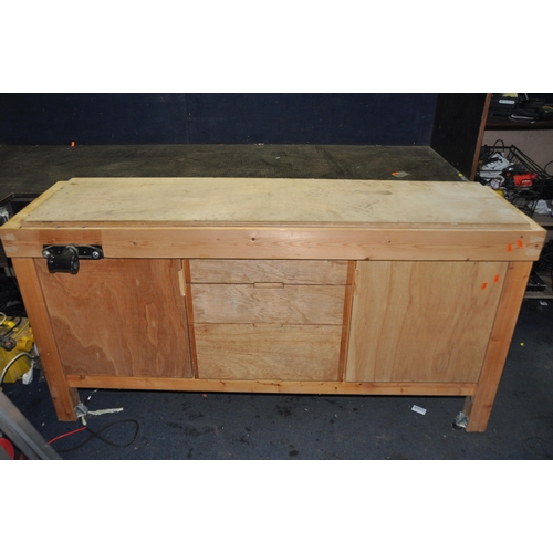 1080 - A BESPOKE PINE WORK BENCH with three graduated central drawers flanked by two cupboard doors, a vice... 