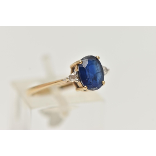 15 - A 9CT GOLD SAPPHIRE AND DIAMOND RING, designed as a central oval sapphire flanked by rose cut diamon... 