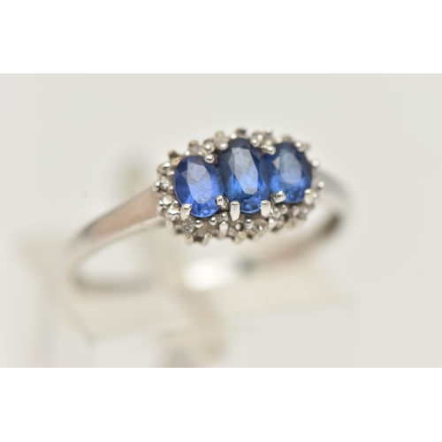 16 - A 9CT WHITE GOLD SAPPHIRE AND DIAMOND RING, designed as three graduated oval sapphires surrounded by... 
