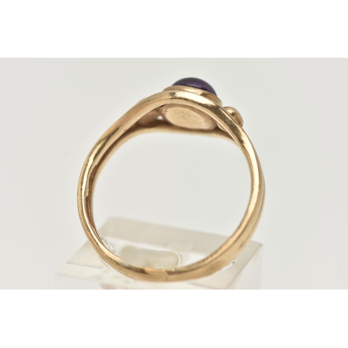 17 - A 9CT GOLD AMETHYST RING, designed as a central amethyst cabochon in a collet setting to the outer c... 