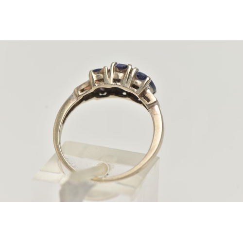 24 - A 9CT GOLD GEMSET RING, three oval cut tanzanite, prong set in white gold leading on to baguette cut... 