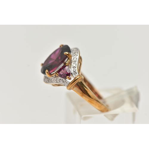 59 - A 9CT GOLD GARNET AND DIAMOND DRESS RING, centring on an oval cut garnet, four claw set, flanked by ... 