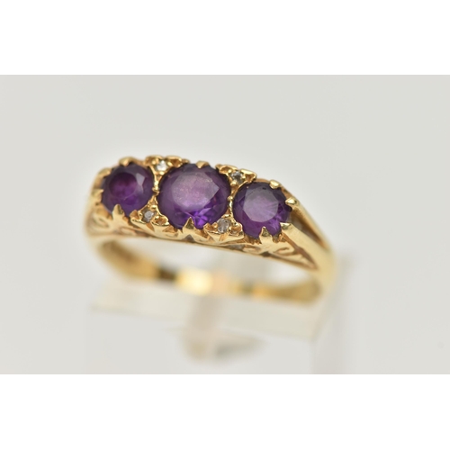 90 - AN 18CT GOLD THREE STONE RING, three round cut amethysts, prong set in yellow gold, scrolling detail... 