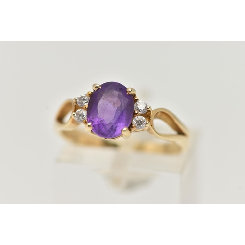 98 - AN AMETHYST DRESS RING, a principally set oval cut amethyst with four round cut cubic zirconia, lead... 