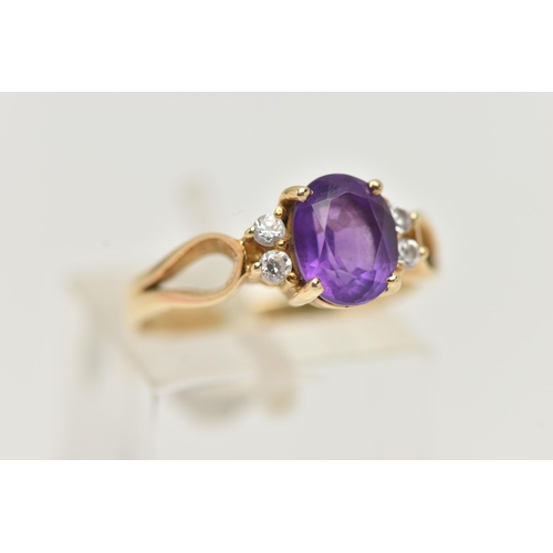 98 - AN AMETHYST DRESS RING, a principally set oval cut amethyst with four round cut cubic zirconia, lead... 