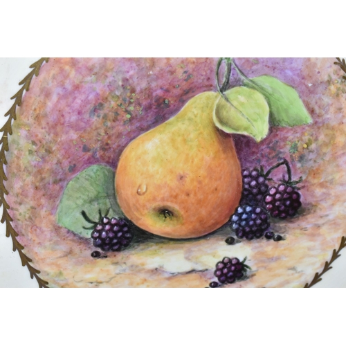 416 - TWO FRAMED HAND PAINTED CERAMIC PLAQUES, signed M. Harnett, painted with fruit in a central circular... 