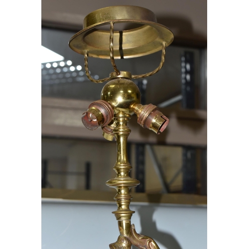 469 - A LARGE BRASS FIGURAL TABLE LAMP, with three bulb fittings at the top, brass gimble and two flame fo... 