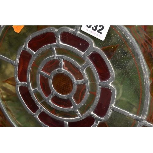 532 - A CIRCULAR STAINED GLASS PANEL, on a metal frame, decorated with a central Tudor rose motif, inside ... 