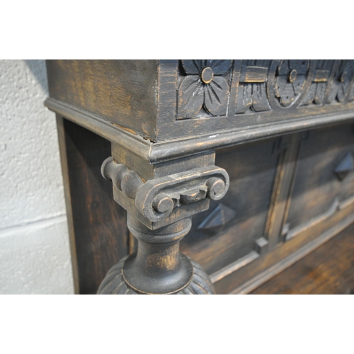 1296 - AN EARLY 20TH CENTURY OAK SIDEBOARD, the raised back with floral carving, geometric panels, on acorn... 