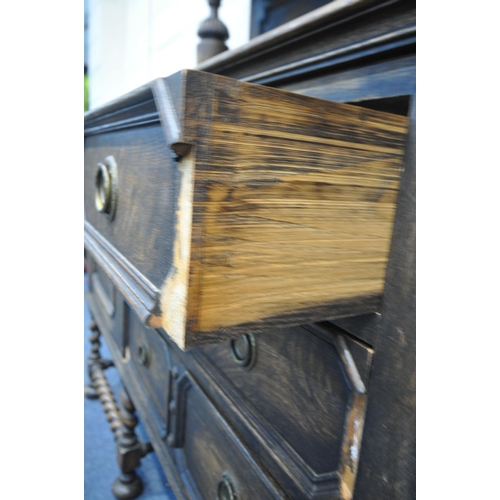 1296 - AN EARLY 20TH CENTURY OAK SIDEBOARD, the raised back with floral carving, geometric panels, on acorn... 