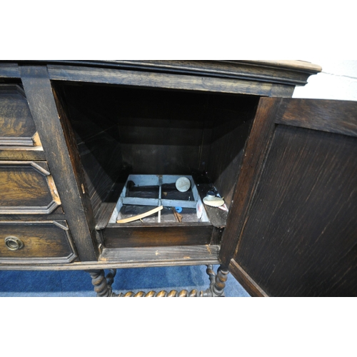 1296 - AN EARLY 20TH CENTURY OAK SIDEBOARD, the raised back with floral carving, geometric panels, on acorn... 