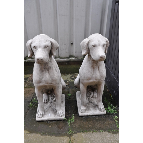 1015 - A PAIR OF COMPOSITE GARDEN SITTING DOG STATUES