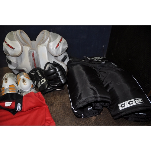 1059 - A BAG CONTAINING ICE HOCKEY CLOTHING, PADS AND HELMET by Reebok, CCM, Bauer, Sherwood etc T shirts a... 