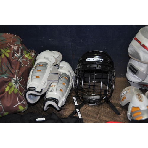 1059 - A BAG CONTAINING ICE HOCKEY CLOTHING, PADS AND HELMET by Reebok, CCM, Bauer, Sherwood etc T shirts a... 