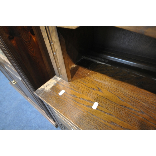 1309 - A 20TH CENTURY OAK BOOKCASE, fitted with four lead glazed doors, flanking a central shelving section... 