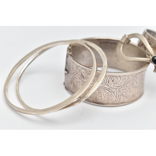 109 - THREE SILVER BANGLES AND TWO WHITE METAL BANGLES, the first a silver wide hinged bangle, with scroll... 