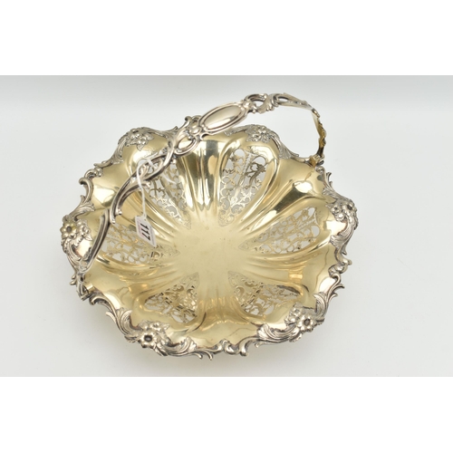 117 - A WHITE METAL CAKE BASKET DISH, the dish with openwork foliate detail within a floral and scrolling ... 