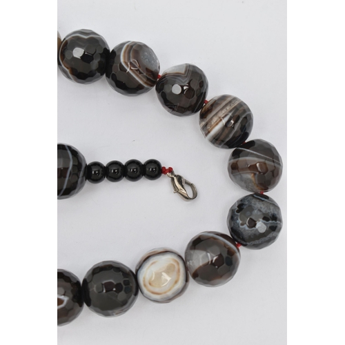 85 - A BANDED AGATE BEAD NECKLACE, faceted circular beads, measuring approximately 16.1mm, with smaller p... 