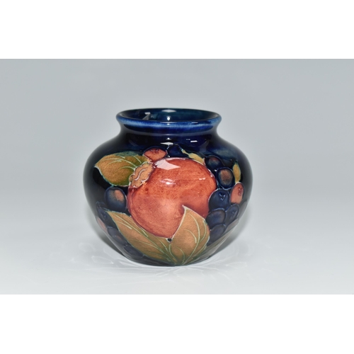 304 - A MOORCROFT POTTERY POMEGRANATE VASE, of squat form, tube lined in Pomegranate pattern on a deep blu... 