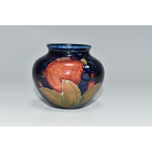 304 - A MOORCROFT POTTERY POMEGRANATE VASE, of squat form, tube lined in Pomegranate pattern on a deep blu... 