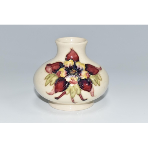 307 - A MOORCROFT POTTERY SQUAT COLUMBINE VASE, tube lined with purple, red and yellow columbine flowers o... 